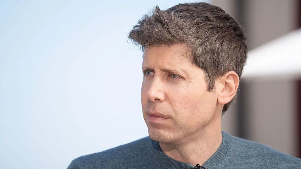 سام آلتمن با چهره‌ای جدی و پوشیده در پلیور آبی‌خاکستری