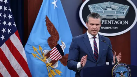 Getty Images Secretary Hegseth in front of US flags at The Pentagon
