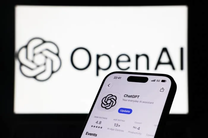Phone displaying ChatGPT app with OpenAI logo in the background