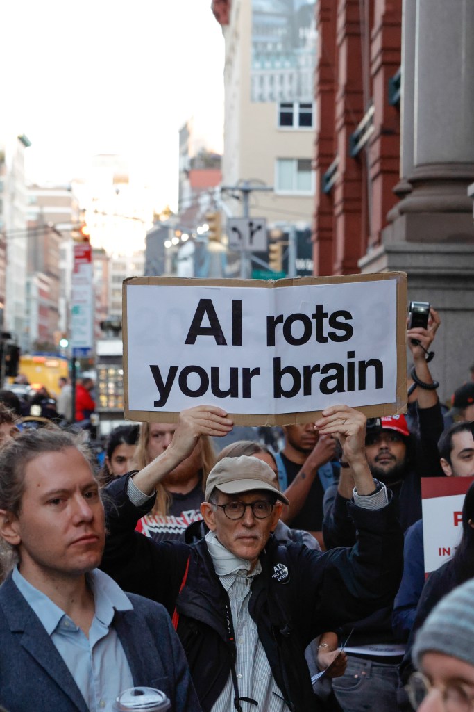 معترضی با تابلویی با مضمون هوش مصنوعی مغز شما را فاسد می‌کند، در تجمعی مقابل دفتر OpenAI