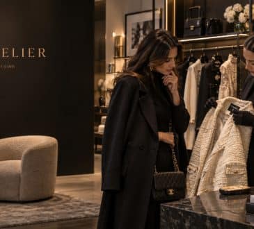 Woman and fashion specialist examining luxury women’s wear in a premium boutique as resale value becomes part of purchasing decisions.