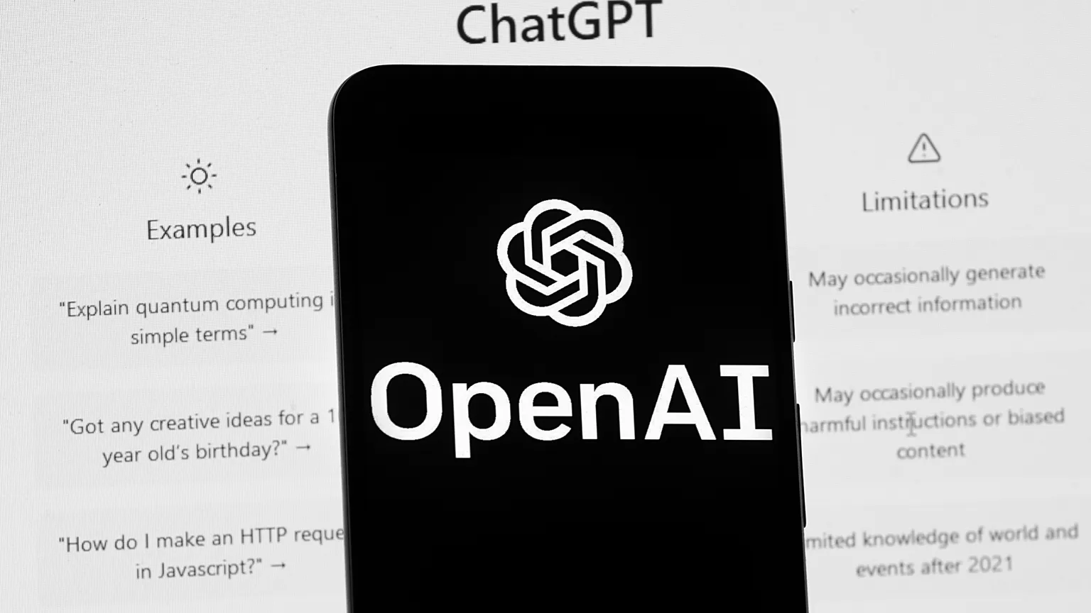 File- The OpenAI logo is seen on a mobile phone in front of a computer screen displaying the ChatGPT home screen, March 17, 2023, in Boston.