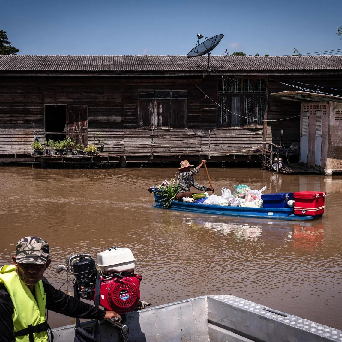 A food vendor paddling past a flooded neighbourhood in Sena district in the central Thai province of Ayutthaya.