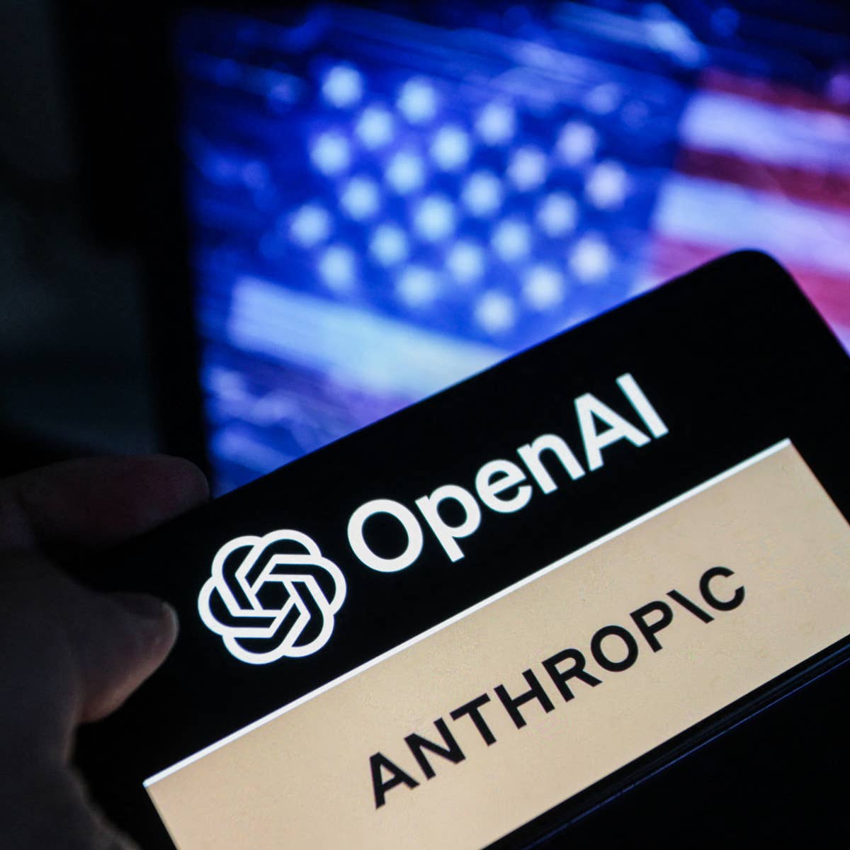نمایش نشان‌های OpenAI و Anthropic روی صفحه یک تلفن هوشمند در برابر پس‌زمینه‌ای محو از پرچم آمریکا